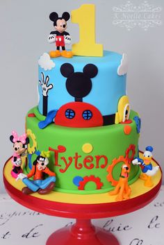 a birthday cake with mickey mouse and other characters on it