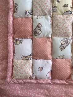 a pink and white quilted blanket with cats on it