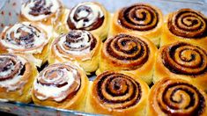 many different types of cinnamon rolls in a glass dish