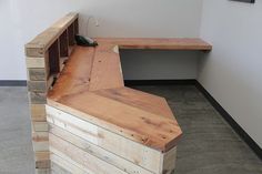 a bench made out of wooden pallets in an empty room with no one sitting on it