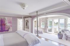 a large bedroom with purple walls and white furniture