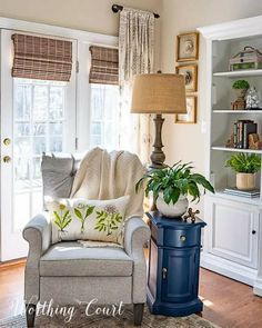 a living room filled with furniture and a blue table next to a lamp on top of a hard wood floor