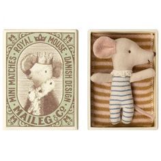 a small stuffed mouse in a box next to a postage stamp with an image of a rat on it