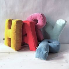 three different colored pillows sitting next to each other