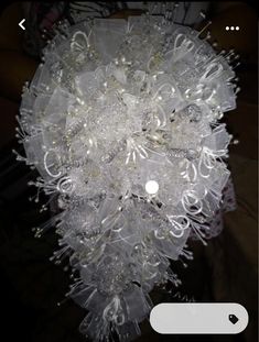 the bouquet is made up of white and silver flowers with pearls on it's petals