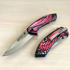 two pink and black butterfly knives sitting on top of each other