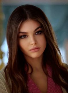 a woman with long brown hair is posing for the camera and looking at the camera