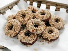 a bunch of doughnuts that are sitting on a paper towel in a basket