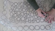 a person is drawing circles on a sheet of paper