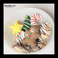 a white bowl filled with assorted decorated cookies