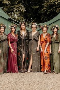 a group of women standing next to each other wearing dresses and flowers in their hair