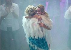 two women hugging each other on stage