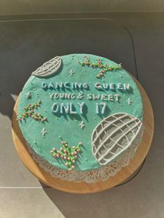 a cake that is sitting on top of a wooden plate with the words dancing queen young and sheet only 17