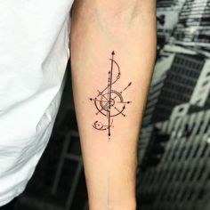 a man's arm with a compass tattoo on it