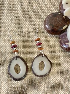 Handmade in Ecuador Earrings Length: 2.5 Inches Material: Tagua Nut Due to this item being handmade and the nature of the Tagua Nut the size and the color may vary from piece to piece Unique Brown Hoop Earrings For Gift, Unique Brown Round Earrings, Brown Teardrop Earrings For Beach, Brown Teardrop Earrings For The Beach, Rustic Brown Drop Earrings, Handmade Earthy Round Earrings, Earthy Handmade Round Earrings, Earthy Jewelry With Natural Variations, Artisan Brown Jewelry For Beach