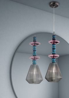 three lights hanging from a ceiling in front of a mirror