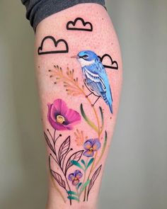 a woman's leg with flowers and birds painted on it