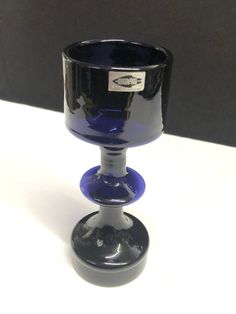 a blue glass cup sitting on top of a white table