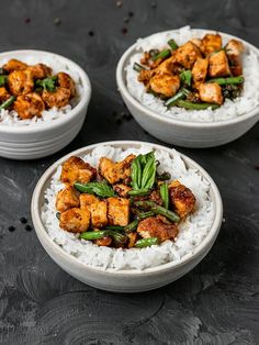 three white bowls filled with food on top of a table