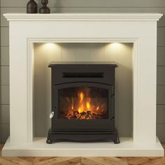 a white fireplace with a lit fire in the center and wood burning on the sides