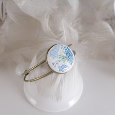 "This beautiful porcelain bracelet was created with love and care. Each element is hand-painted, which makes the floral motifs in shades of delicate blue extremely detailed and realistic. Flowers, decorated on a white background, add subtlety and elegance to this bracelet, and at the same time give it lightness and freshness. Give your loved one something that will remind them of your special relationship every time they look at their wrist. Order today and make your gift an unforgettable souven Adjustable Hand Painted Blue Bracelet, Adjustable Blue Hand Painted Bracelet, Adjustable Blue Hand Painted Bracelets, Blue Floral Print Jewelry For Gift, Blue Floral Print Flower-shaped Jewelry, Porcelain Bracelet, Hand Painted Ring, Small Blue Flowers, Geometric Bangle