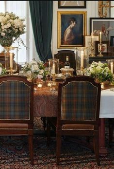 a dining room table is set with flowers and candles