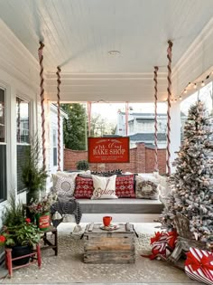 a porch decorated for christmas with red and white decorations