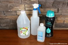 three different types of cleaning products sitting on a wooden table next to a brick wall