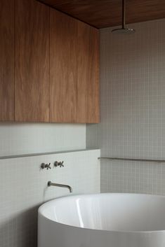 a white bath tub sitting next to a wooden cabinet