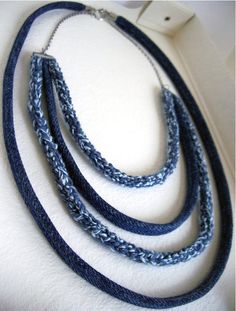 three blue braided necklaces are hanging on the wall