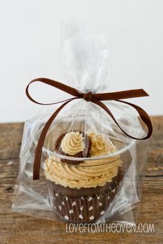 a cupcake in a plastic bag on top of a wooden table