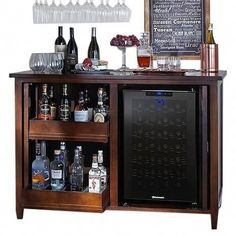 a wooden bar with wine glasses and liquor bottles on the top shelf next to it