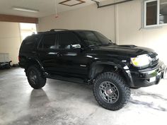 a large black suv parked in a garage