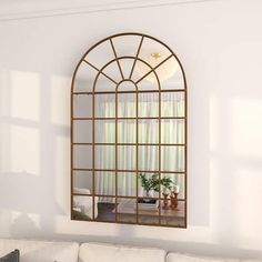 a living room filled with furniture and a large mirror on the wall over a white couch