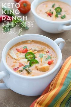 two white bowls filled with soup next to tomatoes