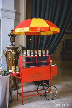 an orange cart with yellow and red umbrella