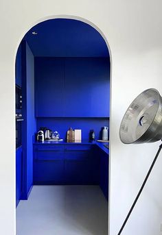 an open door leading into a kitchen with blue cabinets