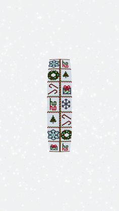 a cross stitch bracelet with christmas decorations on it and snowing in the back ground