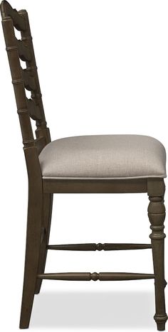 the back of a wooden chair with a beige upholstered seat and wood frame