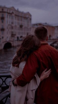 a man and woman standing next to each other on a bridge