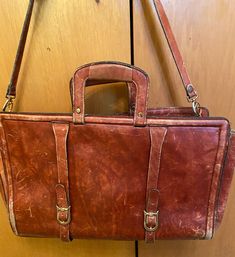 Not sure of its age. I'm guessing the seventies era. In spite of exterior marks on its thick leather it has a lot of years of use left in it. Tons of character! See photos for measurements and condition. Leather strap shows very little wear and handles are solid. Some marks show interiorly. Zipper in nice condition also. This is a quality bag as evidenced by its years of use and continues to be very usable and has a charm all its own!! Retro Business Satchel, Vintage School Bag With Leather Backing, Retro Leather Briefcase For Office, Retro Satchel Briefcase For Office, Retro Rectangular Briefcase For Business, Retro Office Satchel Briefcase, Retro Rectangular Business Briefcase, Vintage Leather-lined Satchel Laptop Bag, Vintage Leather Laptop Bag With Luggage Sleeve