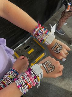 two people with bracelets on their hands and one has the word love written on it