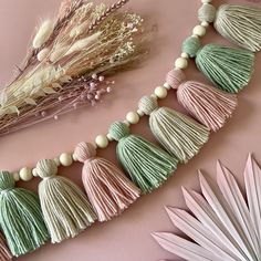 some tassels are laying on a pink surface next to other items and flowers