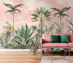 a pink couch sitting in front of a wall with palm trees painted on it's side