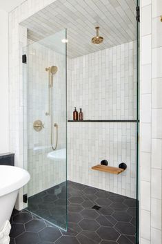 Black and white walk-in shower with brass fixtures and fold-out shower seat White Floor Black Walls Bathroom, Shower Separate From Bathroom, Black Floor White Tile Bathroom, Black Floor White Shower Bathroom, Shower Black Floor White Walls, Black Bathroom Flooring, White Tile Gray Grout Bathroom, Dark Floor Master Bath, White Tub Black Tile