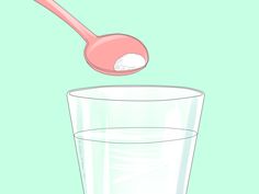 a spoon with sugar in it over a glass of water