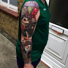 a man wearing a green shirt with tattoos on his arm