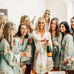 a group of women standing next to each other holding wine bottles and champagne glasses in their hands