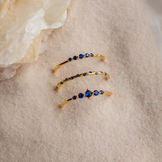 Inspired by the natural calming energy of Sapphire stones, we present our Sapphire Stacking Ring Set (and we’re obsessed!). Three delicate gold rings are adorned with vibrant deep blue sapphires gemstones, reflecting the mesmerizing colors of the summer ocean. The perfect vibrancy of these exquisite rings will become your staple statement accessory for the season. Material: High Quality Solid 925 Sterling Silver Finish: Sterling Silver ∙ 18K Gold Featuring a Set of 3 Sapphire CZ Gemstone Rings ( Everyday Sapphire Ring Jewelry, Blue Sapphire Stackable Gemstone Rings, Blue Sapphire Stackable Rings With Gemstones, Celestial Blue Gemstone Rings, Sapphire Stackable Rings With Gemstone, Blue Celestial 14k Gold Rings, Everyday Sapphire Ring, Everyday Blue Sapphire Ring, Blue Sapphire Stackable Birthstone Ring