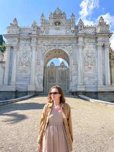 a woman standing in front of an ornate archway